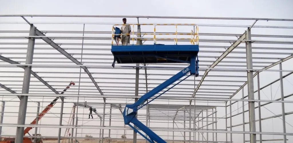 Cropped historical archive photograph of a structural steel warehouse frame and elevated work platform